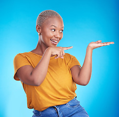 Image showing Decision, pointing and black woman with a smile, presentation and advertising on a blue studio background. Sales, female person or model with discount deal, sales and choice with promotion or showing