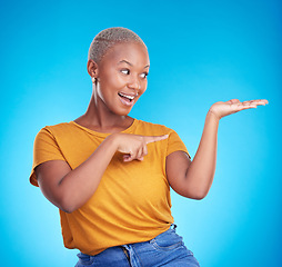 Image showing Decision, choice and black woman showing, presentation and information against a blue studio background. Discount deal, female person and excited model with options, advertising and product placement