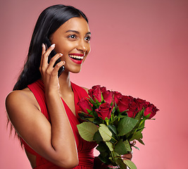 Image showing Phone call, laugh and a happy woman with roses on a studio background for valentines day. Smile, model and face of a young Indian girl with a flower bouquet and smartphone for romance, chat and love