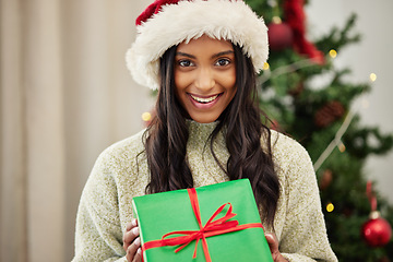 Image showing Christmas, portrait or happy woman with a gift box or present on a holiday celebration at home. Face, smile or excited Indian girl with special product or giveaway prize package in a house in winter