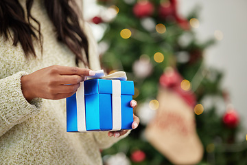 Image showing Closeup, hands and woman with a gift, Christmas and box with a package, living room and celebration. Zoom, female person or girl with a Xmas present, festive season and product with holiday and party