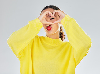 Image showing Woman, portrait and heart hands for love, care or romance in casual fashion against a white studio background. Female person with hand in support emoji, sign and symbol for health or wellness