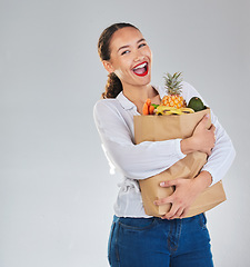 Image showing Excited, portrait and woman grocery shopping for fruit on mockup space in studio isolated on a white background. Bag, food or customer with vegetables for nutrition, healthy diet and supermarket deal