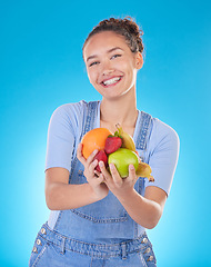 Image showing Happy, diet and portrait of woman with fruit in studio for healthy eating, wellness and wellbeing. Food, lose weight and female person on blue background with apple, orange and banana for nutrition