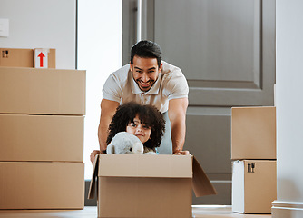 Image showing Father, child and fun with box while moving to new home, real estate and property of house. Happy dad, kid and ride in cardboard while packing, playing games and celebration of relocation or freedom