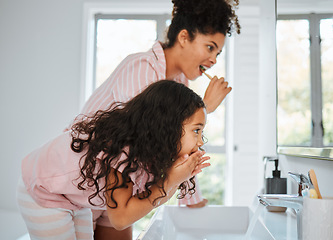 Image showing Mom, girl cleaning teeth and together in bathroom with toothbrush, toothpaste and morning routine in family home. Kid, mother and brushing tooth for hygiene, grooming and teaching healthy dental care