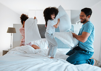 Image showing Happy family, pillow fight and playing on bed in the morning together for fun bonding at home. Father, mother and playful children enjoying game, entertainment or fighting with pillows in the bedroom