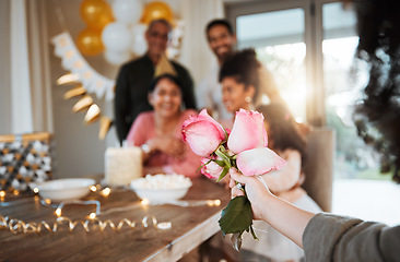 Image showing Roses, family and hand with a gift for a celebration at a birthday, mothers day or party in a house. Giving present, love and a child with flowers for women or grandmother to celebrate mothers day