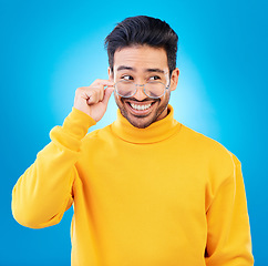 Image showing Thinking, glasses and Asian man with ideas, solution and happiness against a blue studio background. Male person, option and model with eyewear, opportunity or choice with a smile and problem solving