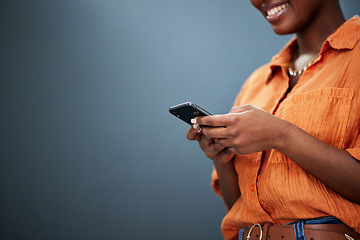 Image showing Typing, mockup and hands with a phone on a dark background for communication or social media. Smile, space and a black woman with a mobile for an app or chat isolated on a studio backdrop for web