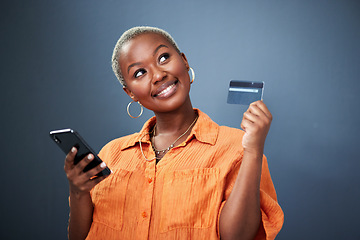 Image showing Thinking, phone and credit card with a black woman online shopping in studio on a gray background. Mobile, ecommerce and finance payment with a young female shopper searching for a deal or sale