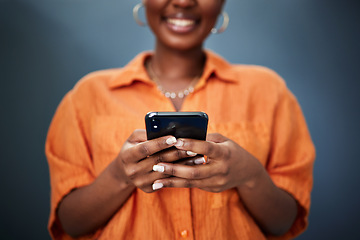 Image showing Typing, closeup and hands with a phone on a dark background for communication or social media. Smile, contact and a black woman with a mobile for an app or chat isolated on a studio backdrop for web