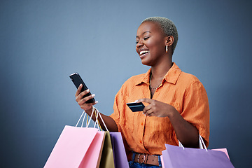 Image showing Bags, shopping and black woman with a credit card, cellphone and ecommerce on a grey studio background. Female person, shopper or model with smartphone, boutique items or payment with retail or smile