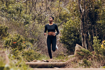 Image showing Forest, running and woman of fitness, body training and cardio wellness, outdoor challenge or hiking in nature. Runner, athlete or african sports person for workout goal or marathon exercise in woods