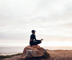 Image showing Lotus pose, woman and yoga at the beach, fitness and meditation with spiritual wellness in nature. Exercise, zen and female yogi on rock outdoor with holistic healing and calm, sea and mindfulness