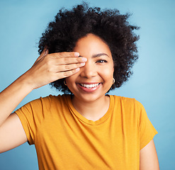 Image showing Happy, cover eye and portrait of a woman for comedy, funny and vision check. Smile, confident and a young girl with a hand on face for positivity and a joke isolated on a blue background in studio