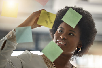 Image showing Black woman, writing or entrepreneur brainstorming ideas on glass board with startup strategy in office. Face, sticky notes or businesswoman planning a schedule, timeline or tasks for company growth