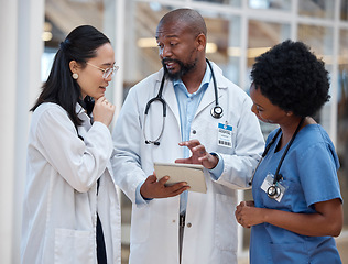 Image showing Doctors, medical and healthcare team work on paperwork or planning in a hospital and talking about medicine strategy. Document, diversity and professional group in discussion or conversation