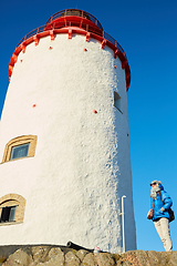 Image showing Beautiful woman posing near lighthouse. Travel the world concept