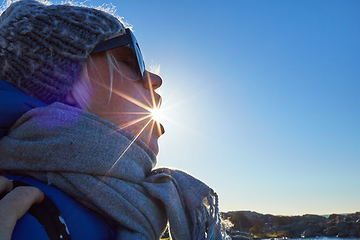 Image showing Portrait a beautiful young woman in a woolen hat and the sun is shining from the mouth