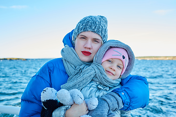 Image showing Attractive young woman with her little cute daughter are spending time together outdoors