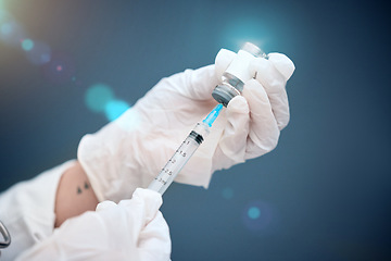 Image showing Closeup, hands and vial with medicine, injection and needle with a doctor on a blue studio background. Zoom, gloves and medical professional with healthcare, needle and vaccine with pharma research