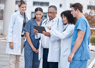 Image showing Tablet, doctors and medical people at hospital outdoor with clinic management, research and online teamwork. Group, telehealth and healthcare staff, nurses and mentor with digital technology training