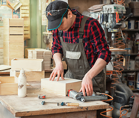 Image showing The worker makes measurements of a wooden board