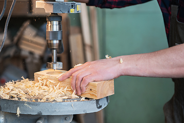 Image showing Carpenters with electric drill machine drilling wooden board