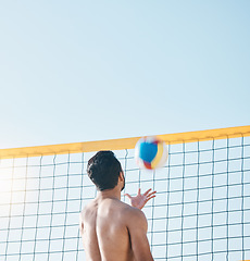 Image showing Sports, beach or man with volleyball on blue sky for exercise, fun competition or contest with mockup space. Back of male person throw to serve ball at sea for fitness, outdoor summer games or action