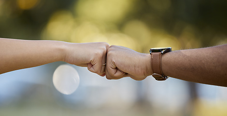 Image showing Hands, motivation and fist bump with people outdoor on a blurred background for unity or solidarity. Teamwork, partnership and trust with friends outside together for team building or support