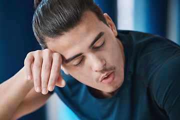 Image showing Exercise, sweat and a tired sports man breathing in the gym after an intense or physical workout for health. Fitness, fatigue and a young male athlete or runner finished with his cardio training