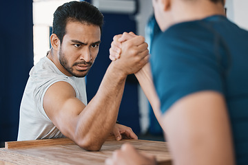 Image showing Strength, motivation and male people arm wrestling on a table while being playful for a challenge. Rivalry, game and men athletes doing strength muscles battle for fun, bonding and friendship in gym.