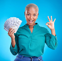 Image showing Woman portrait, okay sign and money fan for bonus, financial success and winning, finance loan with wow. African person or winner surprise, yes and notes or cash profit on a studio, blue background