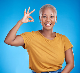 Image showing Black woman, ok sign and smile in studio portrait for good review, vote and icon by blue background. African gen z girl, young student and hand for emoji, symbol and happy for feedback, like and yes