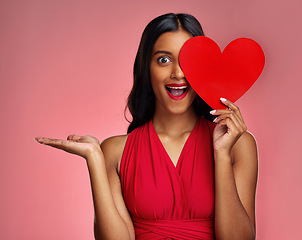 Image showing Woman, happy surprise and heart, marketing mockup in red dress and promotion of love on pink background. Valentines Day advertising, female model in portrait and wow expression for branding in studio