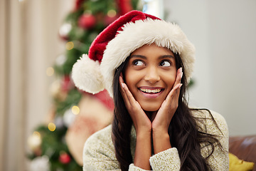 Image showing Happy woman, face and thinking with Christmas hat by tree for festive season, celebration or gift surprise at home. Female person with smile in relax for holiday, weekend or December party in house