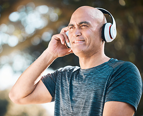 Image showing Happy man, headphones and listening to music in nature for workout, training or exercise outdoors. Male person or mature runner smile with headset for audio streaming or online sound track outside