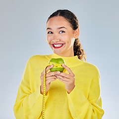 Image showing Tape measure, apple and portrait of woman with fruit in studio for healthy eating, wellness and balance diet. Vegan, lose weight and female person on white background with food for nutrition or detox