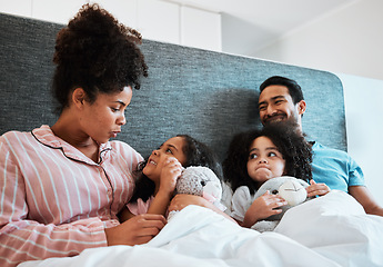 Image showing Love, conversation and kids laying with their parents in their bedroom talking, relaxing and bonding. Happy, smile and girl children speaking and resting with their mother and father at their home.