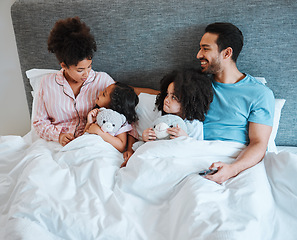 Image showing Bonding, discussion and children in the bed with their parents talking and relaxing together in the room. Happy, smile and girl kids speaking for conversation with their mother and father in bedroom.