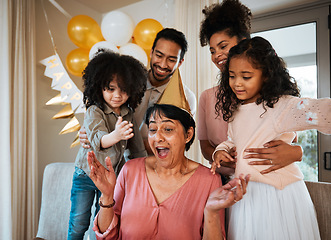 Image showing Birthday, surprise and children with excited grandmother at party for event, celebration and social gathering. Happy family, celebrate and shocked grandma with parents and kids for presents at home