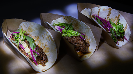 Image showing Three pork carnitas street tacos in yellow corn tortilla.