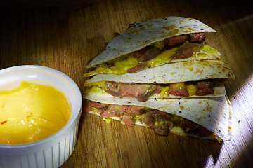 Image showing Mexican quesadilla with chicken, cheese and peppers on wooden table