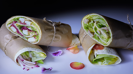 Image showing Healthy lunch snack. Stack of mexican street food fajita tortilla wraps with grilled buffalo chicken fillet and fresh vegetables