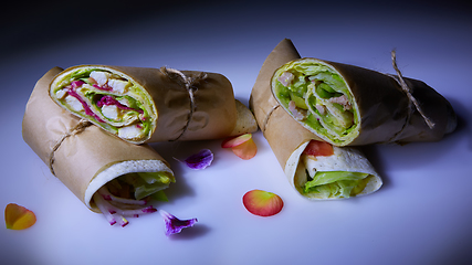 Image showing Healthy lunch snack. Stack of mexican street food fajita tortilla wraps with grilled buffalo chicken fillet and fresh vegetables