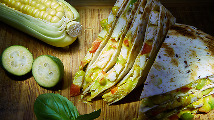 Image showing Mexican quesadilla with chicken, cheese and peppers on wooden table