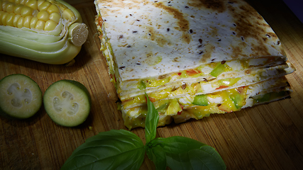 Image showing Mexican quesadilla with chicken, cheese and peppers on wooden table