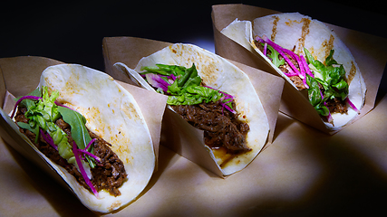 Image showing Three pork carnitas street tacos in yellow corn tortilla.