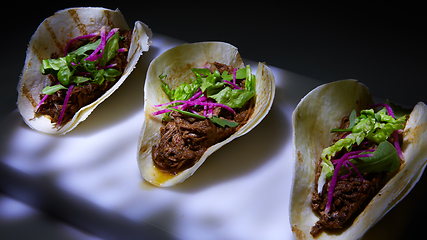 Image showing Three pork carnitas street tacos in yellow corn tortilla.